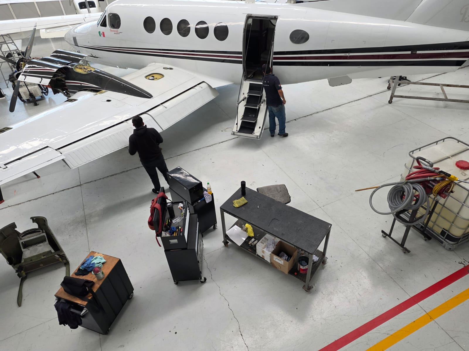 Personal trabajando en una aeronave dentro del hangar